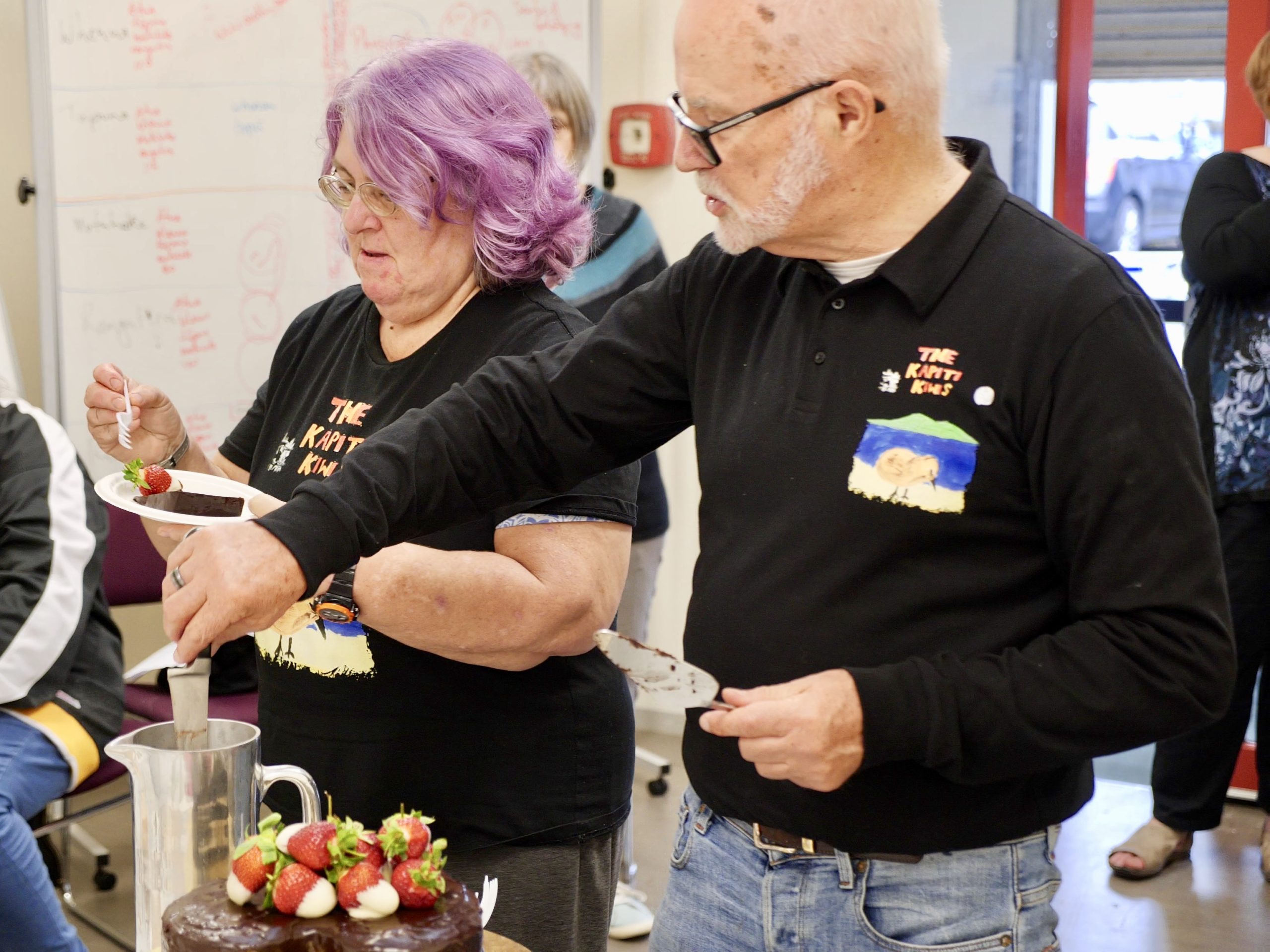 Kapiti Kiwi’s network group Brian (right) serving cake to the Kāpiti Kiwis